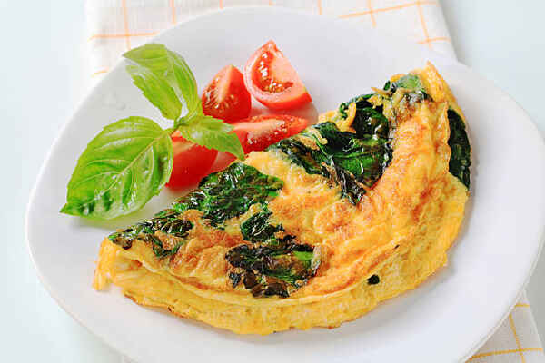 Spinach omelet with cheese and side tomatoes
