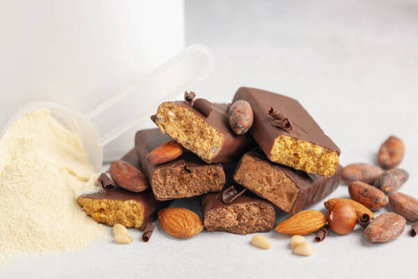Protein Bars for Weight Loss: Unleash Your Slimming Power 5 Chocolate-covered protein bars with nuts and a scoop of protein powder