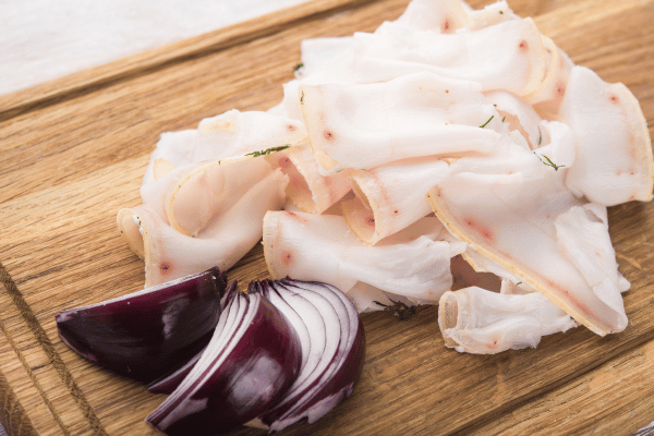 Fat Tallow Sliced with Onion on Wooden Cutting Board.