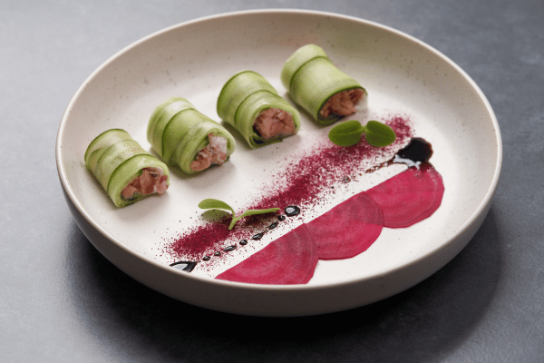 6 Creative Sushi Without Rice Recipes You Need to Try 8 Cucumber wrapped sushi rolls on a plate.