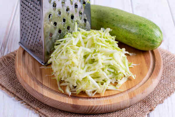 Keto Zucchini Fritters Recipe: Crispy Guilt-Free Indulgence 4 Grated zucchini on a wooden board
