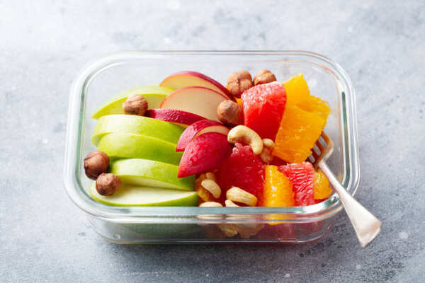 Sliced fruits and nuts in a food container