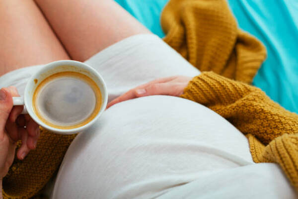 Can You Eat Pork While Pregnant? Master Prenatal Nutrition 11 A pregnant woman drinking a cup of coffee