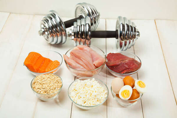 Do You Need Carbs to Build Muscle? The Science Decoded! 7 A set of dumbbells and high-protein foods for muscle growth