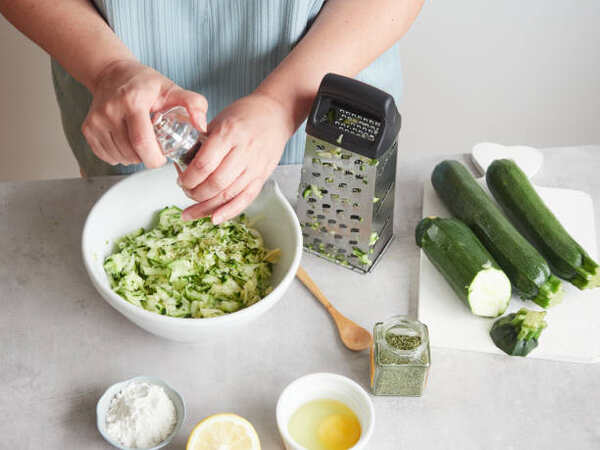 Keto Zucchini Fritters Recipe: Crispy Guilt-Free Indulgence 5 Seasoning grated zucchini with salt and herbs