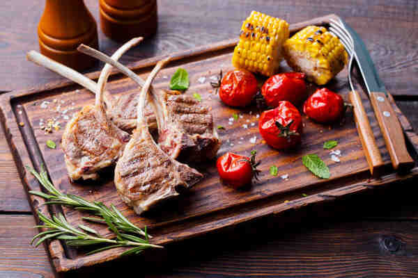 Is Lamb Red Meat? Exploring Its Role in a Balanced Diet 5 Grilled lamb ribs with tomatoes and corn on a wooden board