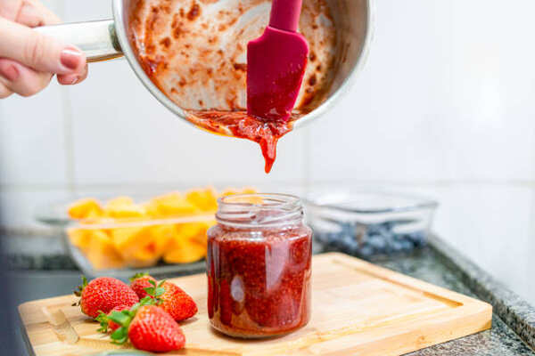 Keto Jelly Recipe: Savor the Sweetness, Skip the Carbs! 5 Pouring homemade strawberry jam into a jar