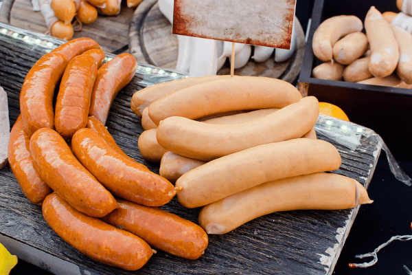 Quick and Easy Chicken Sausage in Air Fryer 7 A close-up photo of three golden-brown sausages, sizzling and perfectly cooked.