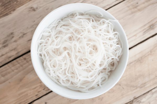 Are Rice Noodles Keto Friendly? Everything You Need to Know 2 A bowl of white rice noodles on a wooden table illustrating if are rice noodles keto or not