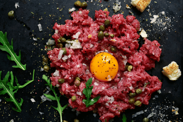 Perfect Steak Tartare: How to Make at Home 5 Smashed steak tartare, bursting with fresh herbs, spices, and mixed with egg yolk.
