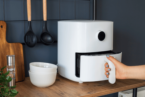 Quick and Easy Chicken Sausage in Air Fryer 5 A sleek, modern white air fryer sits on a kitchen counter, its digital display glowing softly.