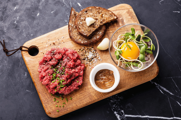 Perfect Steak Tartare: How to Make at Home 6 A perfect meal from above: fresh salad, crispy toast, and expertly prepared steak tartare.