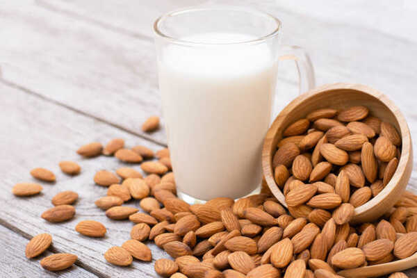 A glass of almond milk with whole almonds