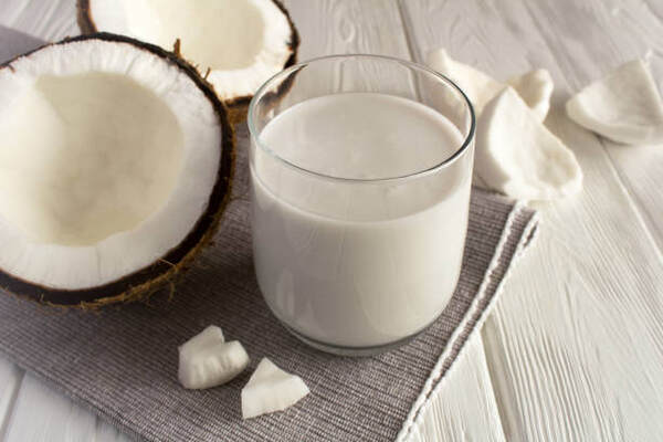 A glass of coconut milk with coconut meat