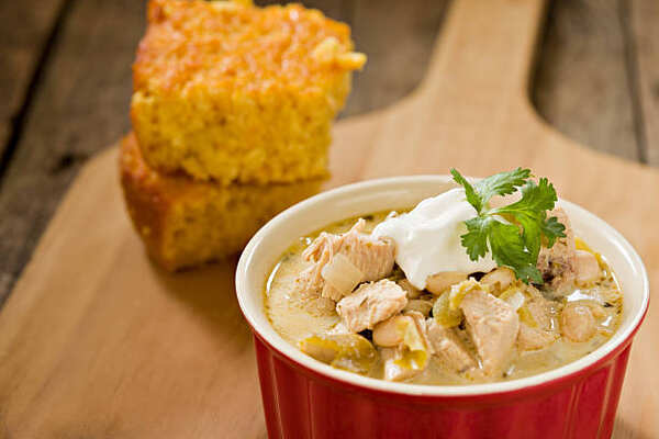 A bowl of white chicken chili with a side of cornbread