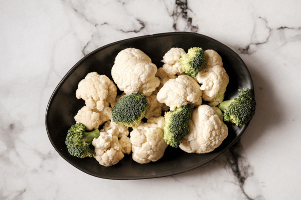 Trader Joe's Cauliflower Thins: Healthy Snack Hacks 2 A plate of sliced and chopped cauliflower on a black plate.