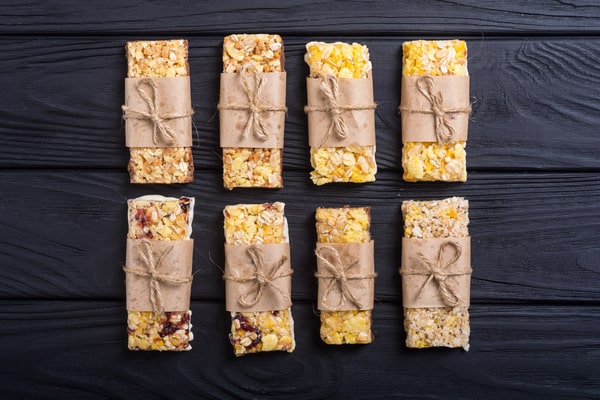 Quest Bars Keto: Your Go-to Snack for Weight Loss 2 Eight homemade granola bars wrapped in brown paper and tied with twine, arranged neatly on a dark wooden surface