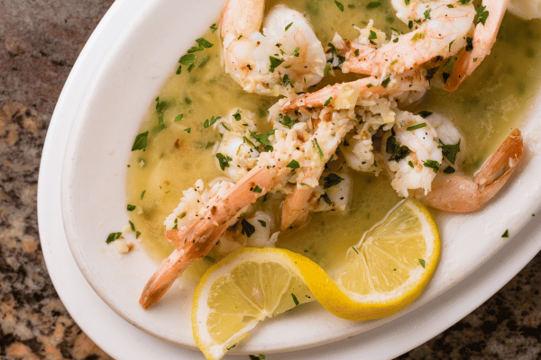 Keto Shrimp Scampi: Quick, Easy, & Low-Carb Recipe 3 Succulent shrimp sautéed in a rich garlic-lemon butter sauce, garnished with fresh parsley and lemon slices.