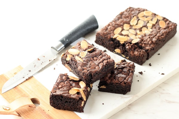 Quest Bars Keto: Your Go-to Snack for Weight Loss 6 Sliced homemade fudge brownies with almonds and chocolate chips on a white cutting board