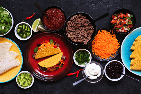 Keto Taco Soup Recipe: The Perfect Low Carb Comfort Food 4 Taco bar tables scene with a variety of ingredients.