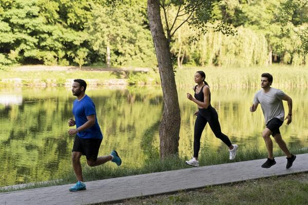 Signs of Gaining Muscle and Losing Fat: Quick and Easy Tips 8 Three people jogging along a lakeside path in a park