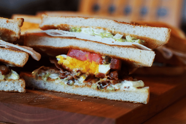 Trader Joe's Cauliflower Thins: Healthy Snack Hacks 8 Sandwich cut in the middle to show colorful fillings and thin crust.