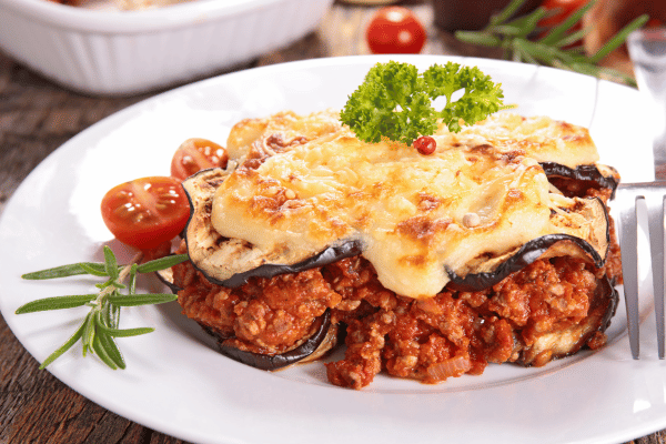 How to Make Keto Moussaka: A Step-by-Step Guide 2 Slice of keto moussaka, beautifully plated and garnished with fresh tomatoes and herbs.