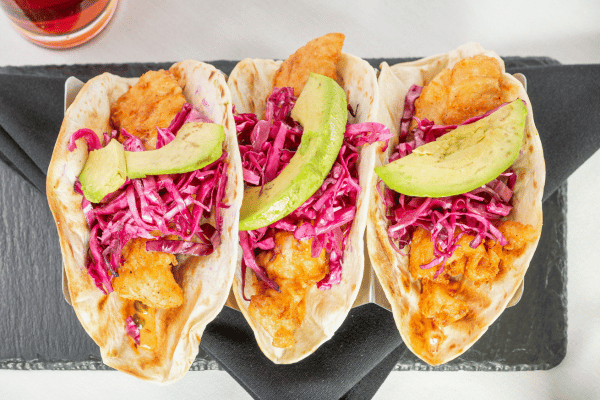 Keto Fish Tacos: The Ultimate Low Carb Recipe and Tips 11 Tacos with breaded fish, shredded cabbage, and avocado.