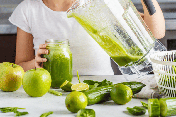 Low Carb Juicing: How to Make Tasty and Healthy Juices 7 A woman pouring apple, cucumber, and lime juice into a jar.