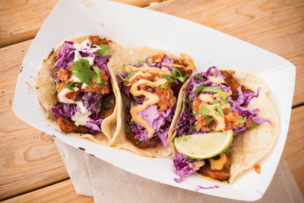 Keto Fish Tacos: The Ultimate Low Carb Recipe and Tips 3 Three rock fish tacos with cabbage and spicy sauce on a white plate.