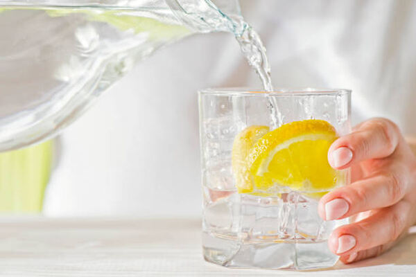 What to Drink During Intermittent Fasting: Hydration Tips 10 Pouring water in a glass with lemon slices