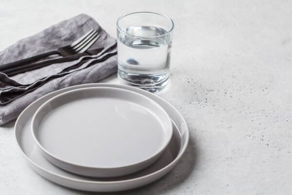What to Drink During Intermittent Fasting: Hydration Tips 2 An empty plate and a glass of water to drink during intermittent fasting