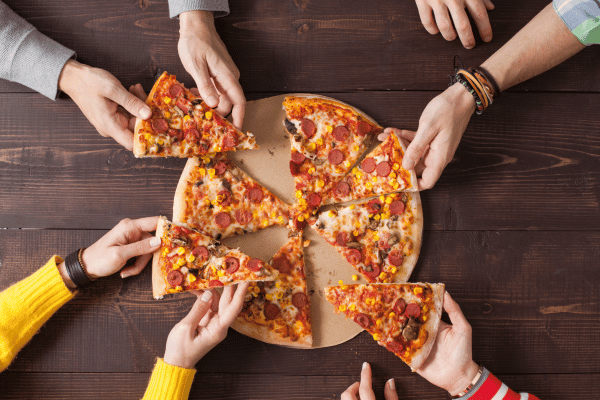 Totino's Pizza Air Fryer Style - Perfectly Crispy and Easy 2 A top view of a pizza with slices missing and hands grabbing more.