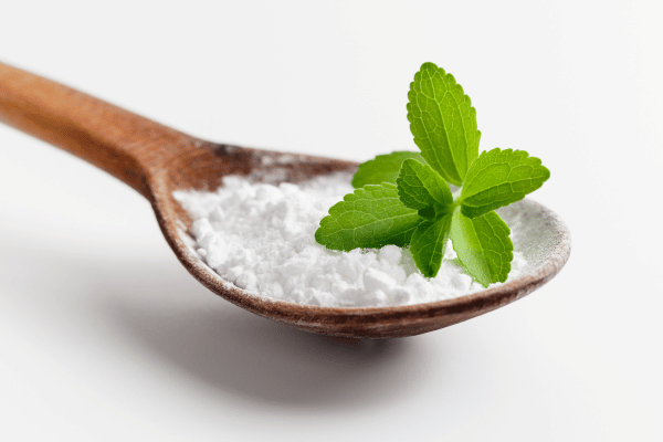 Pyure Keto Recipes: How to Satisfy Your Sweet Tooth 2 A wooden spoon holds a small mound of fine, white Stevia powder.