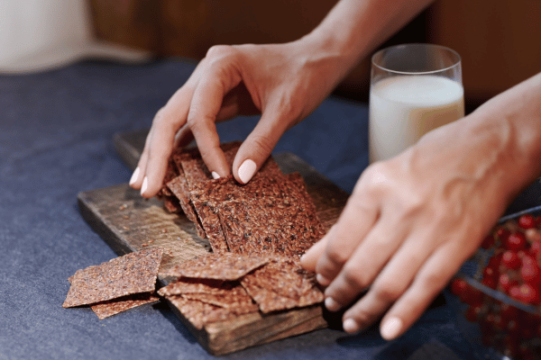Carb Free Bread Recipe: A Simple Guide for Beginners 13 A person sprinkles flaxseeds over slices of bread, adding a nutritious crunch to the surface before baking.