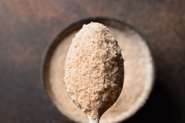 Carb Free Bread Recipe: A Simple Guide for Beginners 20 Psyllium husk powder is spread out on a surface, with a spoonful of the powder prominently displayed on top.