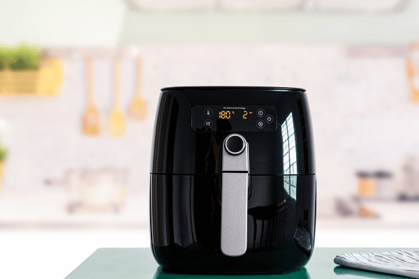 Cooking Dino Nuggets Air Fryer: Fun Variations and Tips 3 A sleek black air fryer sits on a kitchen counter, blending effortlessly with modern appliances and ready for meal prep.