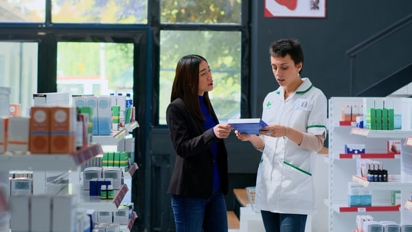 Keto CVS Essentials: Must-Have Products for Your Diet 3 A pharmacist in a white coat assists a customer by explaining a product in a brightly lit pharmacy