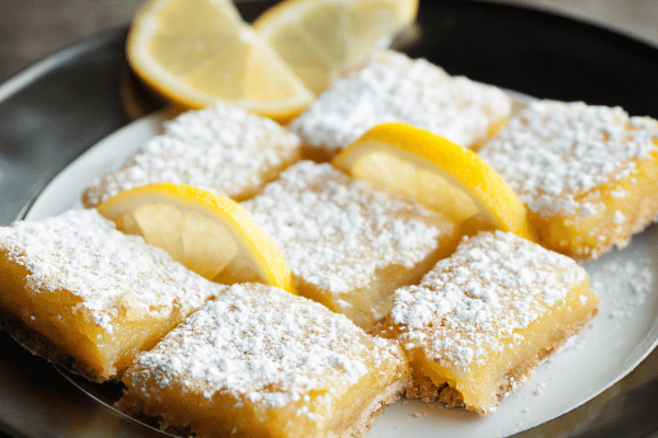 Pyure Keto Recipes: How to Satisfy Your Sweet Tooth 4 A close-up shot of bright yellow lemon bars, dusted with powdered sugar.