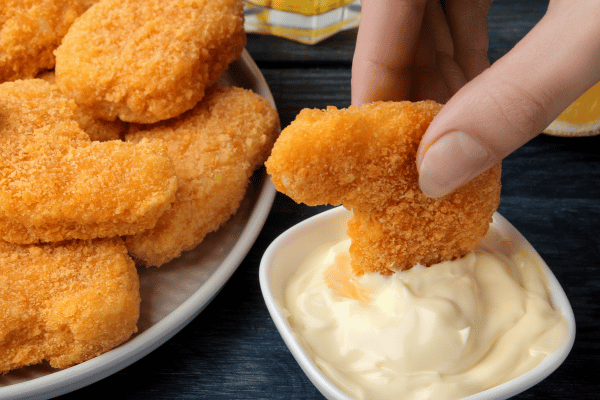 Cooking Dino Nuggets Air Fryer: Fun Variations and Tips 6 Crispy nuggets from the air fryer are being dipped into a bowl of savory sauce, perfect for a tasty snack.
Crispy dino nuggets air fryer are being dipped into a bowl of savory sauce, perfect for a tasty snack.