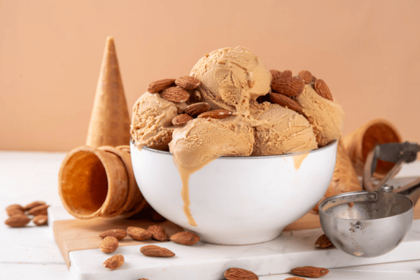 Pyure Keto Recipes: How to Satisfy Your Sweet Tooth 6 A creamy bowl of caramel ice cream topped with crunchy almond nuts.