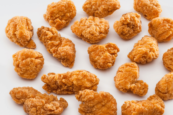 Cooking Dino Nuggets Air Fryer: Fun Variations and Tips 8 Crispy nuggets from the air fryer are scattered across the surface, showcasing their golden, crunchy texture in an inviting spread.
