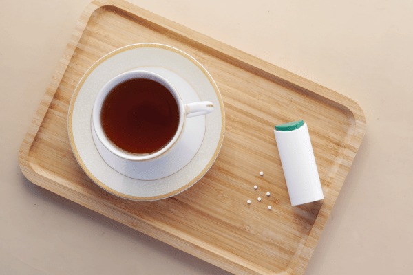 Pyure Keto Recipes: How to Satisfy Your Sweet Tooth 8 A small container of artificial sweetener sits on the table next to a warm cup of tea.