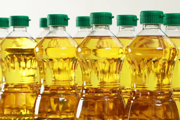 Keto CVS Essentials: Must-Have Products for Your Diet 8 Rows of clear plastic bottles filled with golden MCT oil, each sealed with a green cap, arranged in a pattern