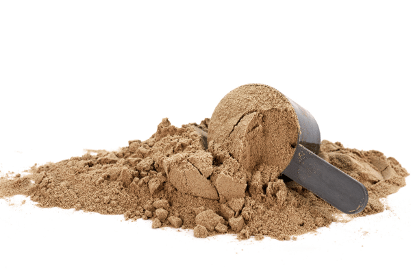 How Low Carb Protein Shakes Can Boost Your Fitness Goals 10 A measuring cup is overflowing with protein shake powder, with some of the powder spilling out.