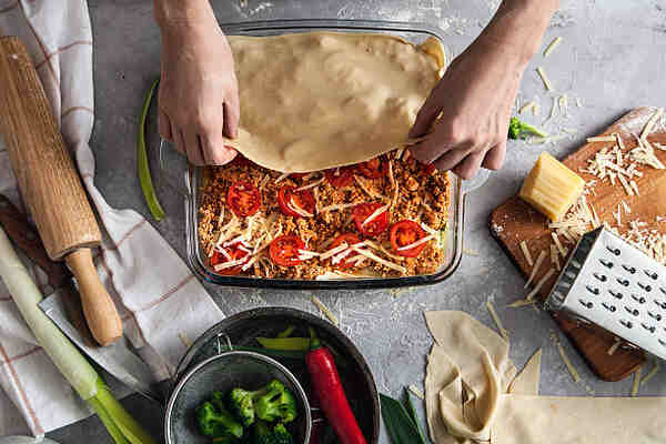 Easy Keto Lasagna: A Delicious Low-Carb Dinner Recipe 7 Assembling lasagna sheets with the meat mixture, tomatoes, and cheese