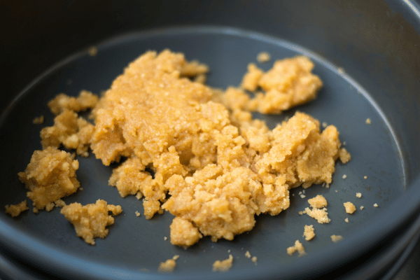 Crushed keto graham crackers scattered on a dish.