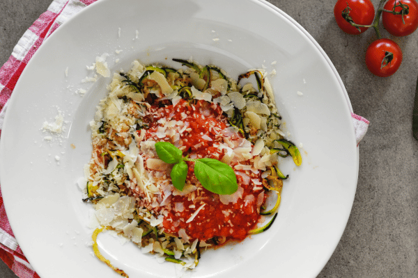 The Best Keto Pasta to Satisfy Your Carb Cravings 12 A plate of low-carb noodles, generously topped with a rich sauce and melted cheese.