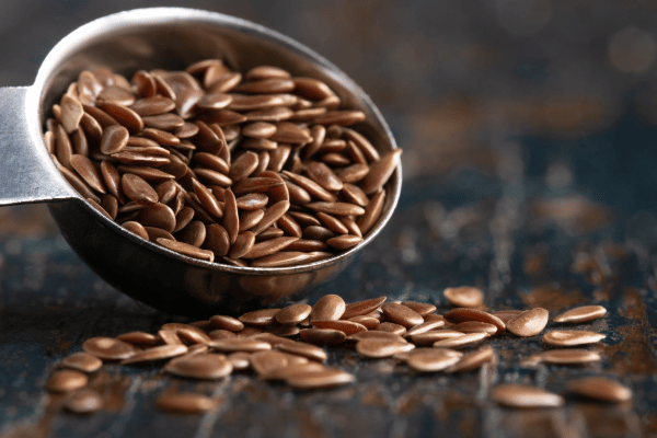 Best Flax Seed: The Ultimate Guide for Maximum Nutrition 4 A close-up of a spoon filled with flax seeds, showing their small, shiny, brown surface.