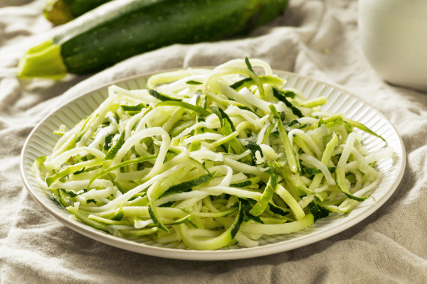 The Best Keto Pasta to Satisfy Your Carb Cravings 4 A stunning plate of best keto pasta made from thin, green cucumber strips.